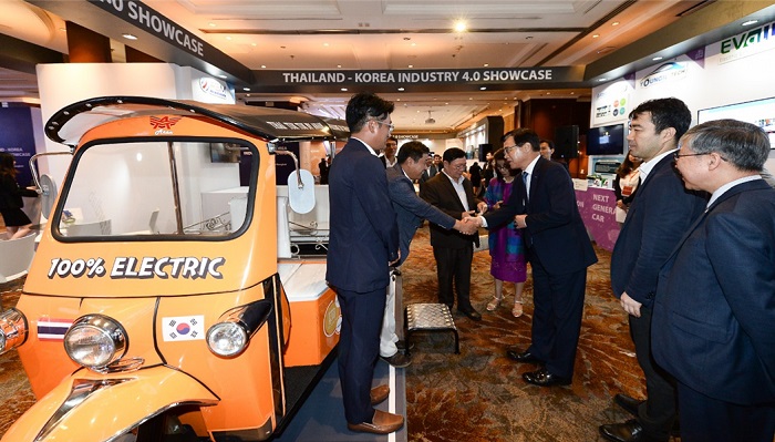 전기뚝뚝이 앞에서 인사를 나누는 행사 관계자들과 참여자들 모습