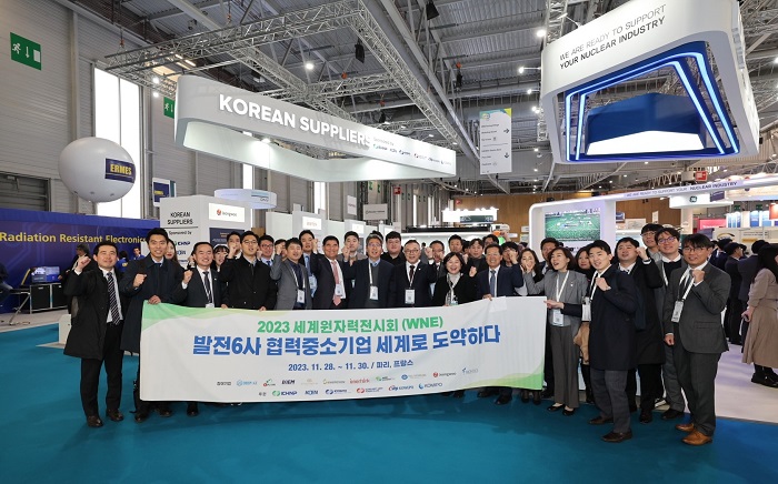 전시회 참가자들 기념촬영 '2023 세계원자력전시회(WNE) 발전6사 협력중소기업 세계로 도약하다'는 카드를 들고 있다