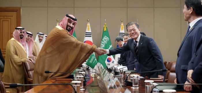 회담장 테이블 중앙에서 사우디아라비아 모하메드 왕세자와 문재인 대통령이 악수하고 있다