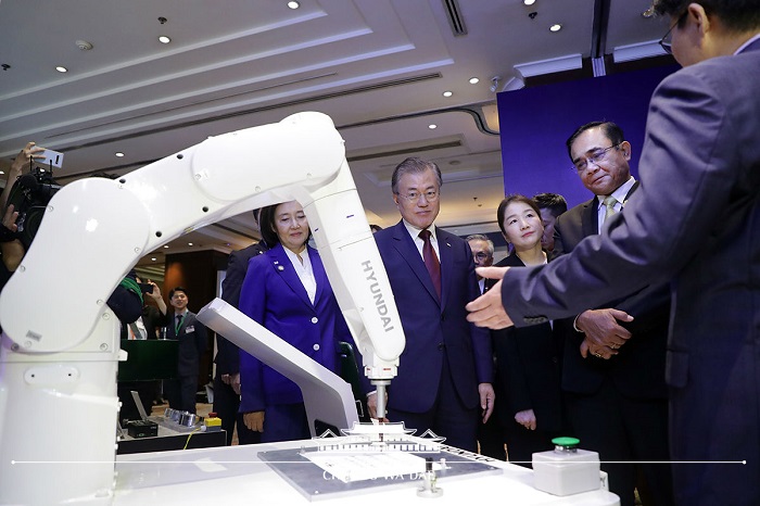 현대로보틱스의 지능형 로봇이 붓글씨로 ‘한국과 태국이 함께 만드는 미래’라는 문구를 한글과 태국어로 쓰는 모습을 지켜보는 양국 정상